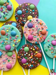 there are many decorated cookies and lollipops on the stick in front of them