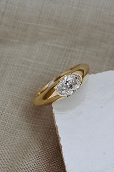 a yellow gold ring with a diamond on top