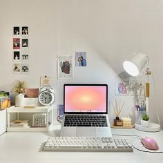 an open laptop computer sitting on top of a white desk next to a keyboard and mouse