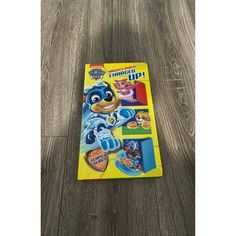 the paw patrol sticker book is laying on a wooden floor