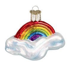 a glass ornament with a rainbow in the clouds