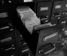 there are many file cabinets with files in the drawer and one is full of folders