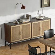 an empty room with two chairs and a sideboard