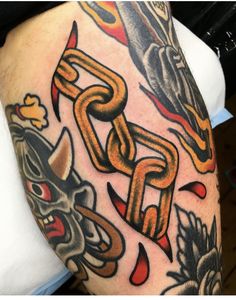 a man's arm with tattoos on it and an orange chain in the middle