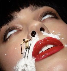 a woman with snow on her face and skis sticking out of her mouth