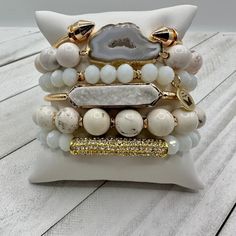 "Elevate your style to new heights with our 'Cloud Nine Chic' bracelet stack – where sass meets sophistication in a sky-high celebration of fabulousness! These bracelets aren't just accessories; they're your personal cloud of chic, ready to whisk you away to a realm where every day is a fabulous adventure. A Real Stunner - Reach for this beautiful stack when you want to stand out from the crowd. Wear them all on one wrist and stack 'em up or wear 3 on one wrist and 3 on the other your favorite watch! Lead & Nickel Free Bracelets are 'one size fits most' and are designed to fit wrists up to 7.5" comfortably Set of 6 Bracelets (4 Stretch, 1 Gold Arrow Cuff & a Gold Bar with a white Druzy Stone Inlay) Pave Crystals Quartz Natural Stone Off White and White Hues Please be aware that due to the Elegant Adjustable Stacked Beaded Bracelets, Elegant Adjustable Stacked Bracelets, White Stackable Bracelets For Party, Trendy White Stackable Jewelry, White Trendy Stackable Jewelry, Trendy White Stacked Bracelets, Chic White Beaded Bracelets, Chic White Beaded Bracelet, Trendy White Crystal Bracelet For Party