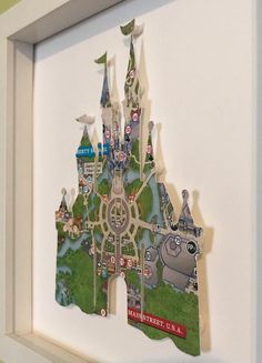 a paper cutout of a castle with lots of buildings and trees in the middle