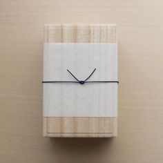 a wooden box with a blue string tied to it on top of a wood surface