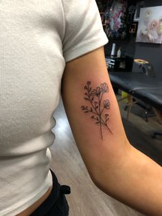 a woman's arm with a flower tattoo on the left side of her arm