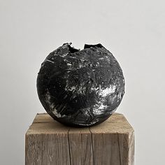 a black object sitting on top of a wooden post