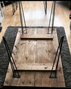 a wooden swing with metal bars on top of carpeted flooring in a living room