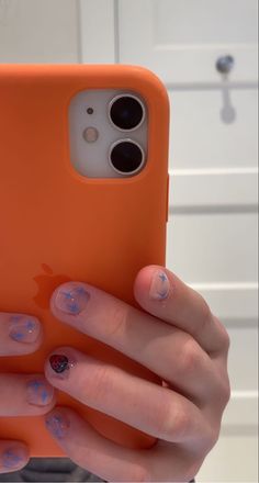 a woman's hands holding an orange phone case