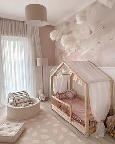 a baby's room decorated in pink and white with a canopy bed, crib, rocking chair and stuffed animals on the floor