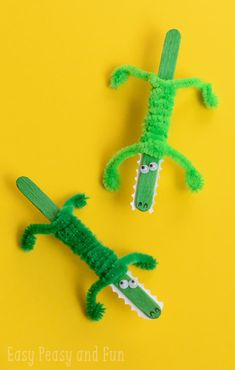 two crocheted alligators are sitting next to each other on a yellow surface