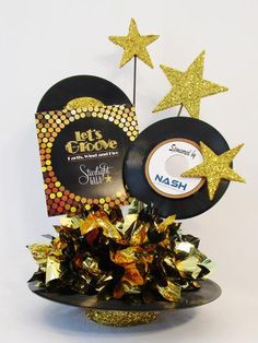 a black record with gold stars on it and a golden tinsel tree topper