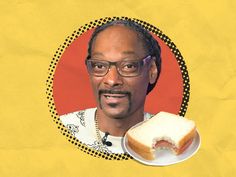 a man with glasses holding a sandwich in front of his face on a yellow background