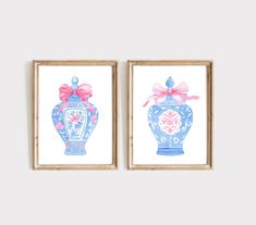 two blue vases with pink bows are hanging on the wall next to each other