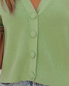 Relaxed Fit 50% Viscose. 28% Polyester and 22% Nylon Hand Wash Cold V-Neckline Long Sleeves Front Fabric Button Closures Not Lined We're all about bold this fall! Our Yganico Button Front Crop Knit Cardigan comes in a bright mint green hue. Designed with front fabric button closures and a v-neckline. Styled with the Carson Black Frame Dark Smoke Polarized Sunglasses. Perfect Hoop Earrings. Gaia Coin Necklace. Mica Chain Choker Necklace. Chic Crossbody Chain Pouch Bag. Kason Distressed High Rise Trendy V-neck Sweater For Spring Workwear, Spring V-neck Sweater With Button Closure, Green V-neck Sweater With Button Closure, Green V-neck Cardigan With Buttons, Green V-neck Cardigan For Day Out, Solid V-neck Cardigan For Day Out, Trendy V-neck Sweater With Button Closure For Spring, Green Sweater With Button Closure For Work, Green Workwear Sweater With Button Closure