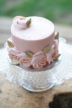 a small pink cake on a glass plate