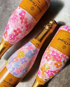 two bottles of champagne with flowers painted on them