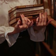 a woman holding several books in her hands