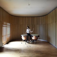 a woman sitting on top of a wooden drum