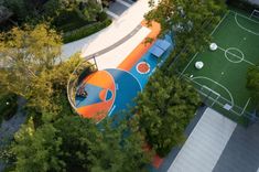 an aerial view of a basketball court in the middle of a park with trees and grass