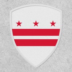 a white and red shield with five stars on the side, against a gray background