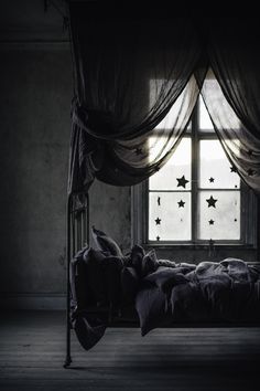 a bed sitting in the middle of a room under a window with stars on it