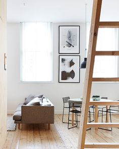 a living room with a ladder and pictures on the wall