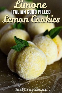 some lemon cookies are sitting on a glass plate with mint sprigs and the words limoone italian curd filled lemon cookies