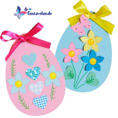 two easter eggs decorated with flowers and hearts, one is pink and the other is blue