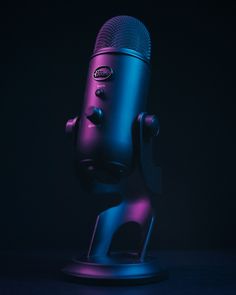 a purple and blue microphone on a black background with the light reflecting off it's side