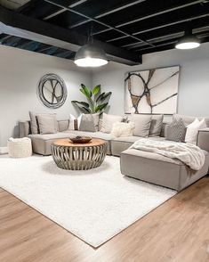 a living room filled with furniture on top of a hard wood floor covered in white rugs