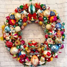 a christmas wreath on a brick wall with ornaments hanging from the front and side of it