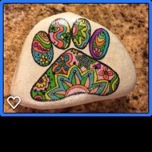 a dog paw painted on top of a rock with flowers and paisleys in the center