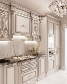 an elegant kitchen with marble counter tops and white cabinetry, along with a chandelier