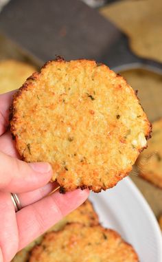 a person holding up a cracker in front of some food