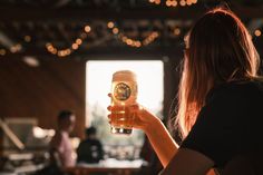 a woman holding up a glass of beer