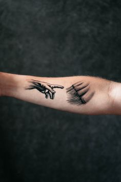 the creation of adam's hands tattoo on the left arm