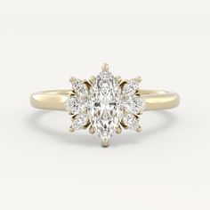 a yellow gold ring with a pear shaped diamond in the center and two small round diamonds at the bottom