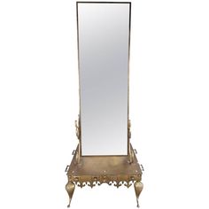 an antique brass mirror with ornate details on the bottom and sides, is displayed against a white background