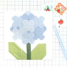 a piece of paper with a flower on it next to a pencil and some scissors