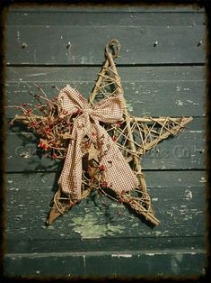 a wooden star decorated with burlocks and red berries hanging from it's side