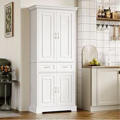 a kitchen with white cabinets and wood flooring in front of a wall mounted wine rack