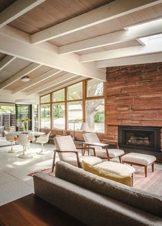 a living room filled with furniture and a fire place in the middle of a room