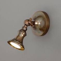 an antique brass wall light on a gray background