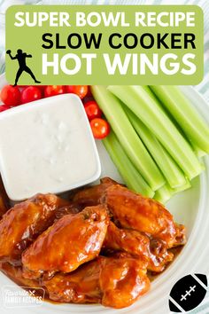 a white plate topped with chicken wings and celery sticks