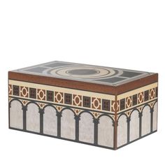 a wooden box with an intricate design on the top and sides, sitting in front of a white background