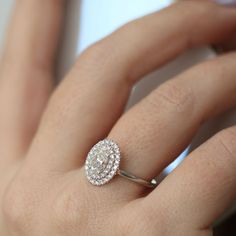 a woman's hand with a diamond ring on it